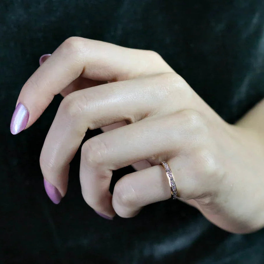 Close-up of a hand with a ring on a dark background