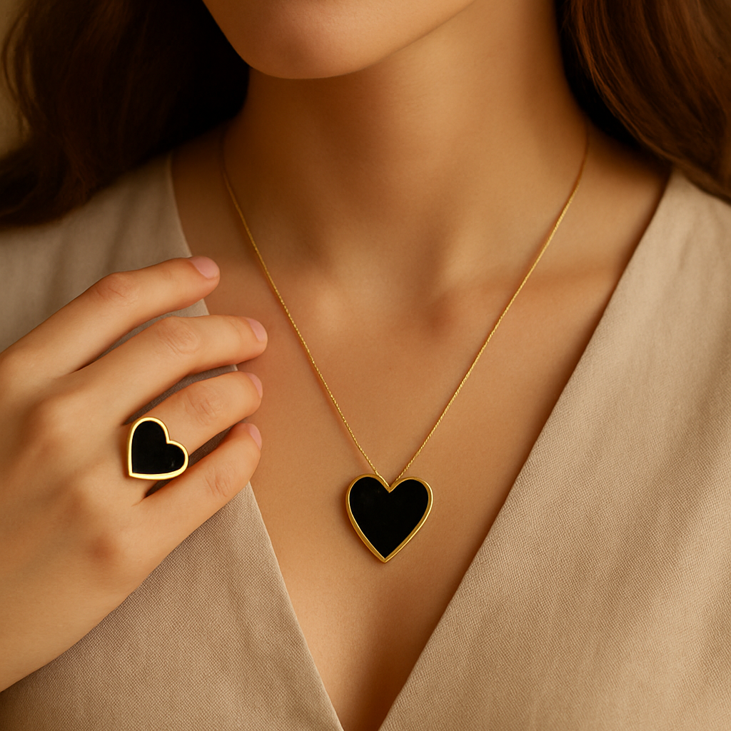 Woman wearing a gold necklace with a black heart pendant, holding another black heart-shaped object.