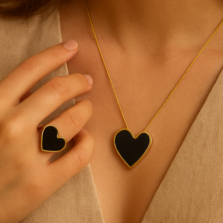Woman wearing a gold necklace with a heart pendant and matching ring.