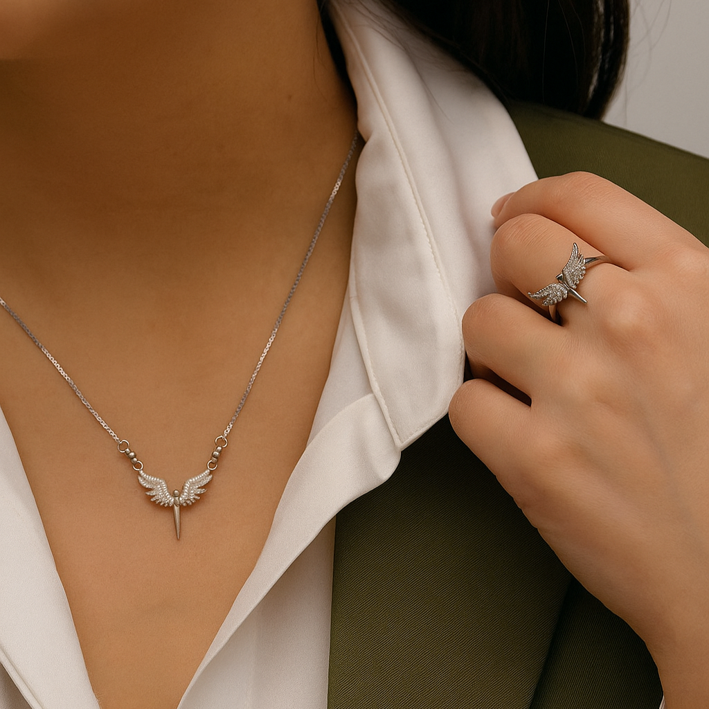 Person wearing a silver necklace and ring, with a blurred background