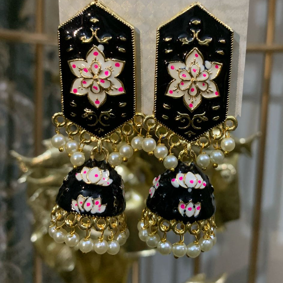 Decorative earrings on a 'Kreative' branded card against a gold cage background
