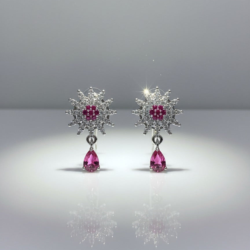 Pair of earrings with pink gemstones on a gray background